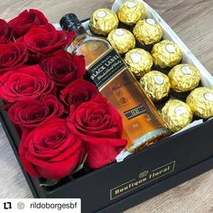 roses and chocolates in a black box with a bottle of alcohol next to it