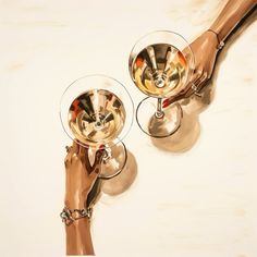 two hands holding wine glasses with gold rims