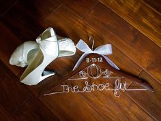 the bride's shoes are on the floor next to their wedding dress hanger