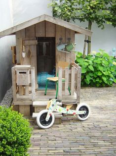 a wooden toy bike parked in front of a house