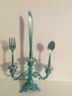 an ornately decorated candelabra with five forks and spoons