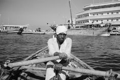 a man sitting on top of a boat in the water