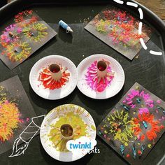 four paper plates with flowers on them sitting on a table next to other art supplies