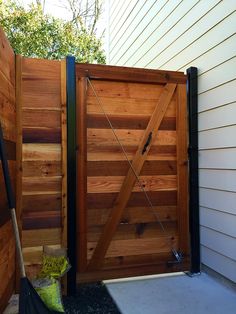 a wooden gate is open on the side of a house