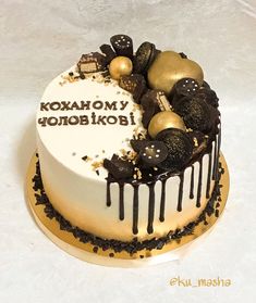 a white cake with chocolate and gold decorations