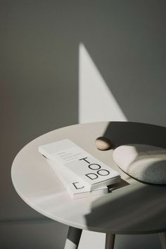 a book sitting on top of a white table next to a pillow and a hat