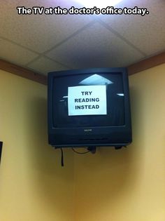 a tv mounted to the side of a wall with a sign reading stay reading instead