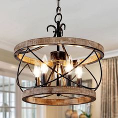 a wooden chandelier hanging from the ceiling in a room with curtains and windows