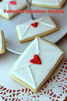 decorated cookies with envelopes and hearts on a white platter for valentine's day