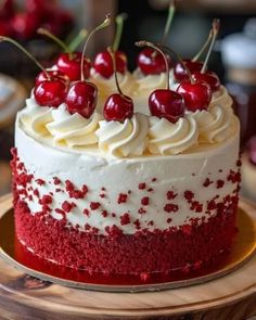 a red velvet cake with white frosting and cherries