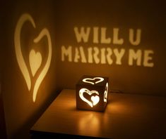 the shadow of a heart is projected on a wall next to a small cube light