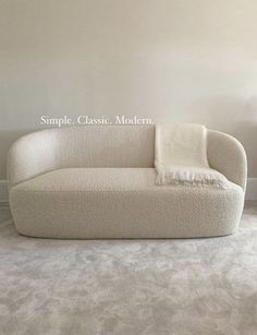 a white couch sitting on top of a carpeted floor next to a wall with the words simple classic modern