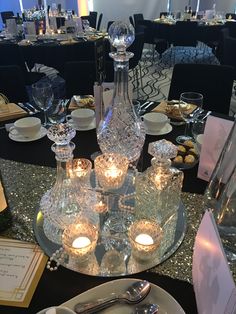 the table is set with silverware and crystal candlesticks for an elegant dinner