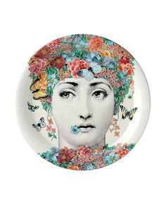 a plate with a woman's face painted on the side and butterflies around her head