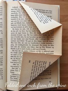 an open book with folded pages on top of it