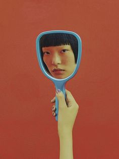 a person holding up a mirror to their face