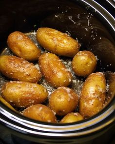 there are many doughnuts in the crock pot on the stove and it looks like they have been fried