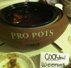 there is a sign that says pro pots and two plates with food on the table