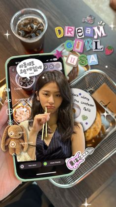 a person holding up a cell phone with food on the screen and writing dream girl