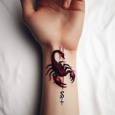 a person with a scorpion tattoo on their left arm and the letter s in red ink