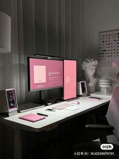 two computer monitors sitting on top of a desk in front of a vase with flowers