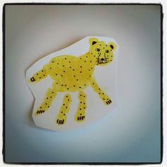 a paper cut out of a cheetah on a white surface