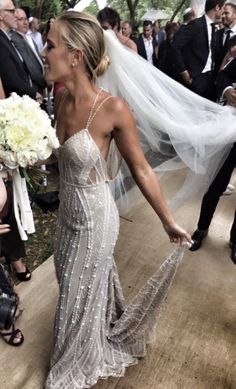 a woman in a wedding dress walking down the aisle