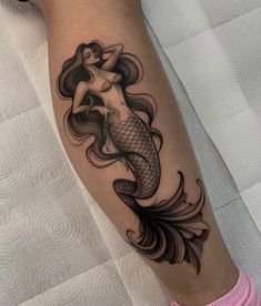 a woman with a fish tattoo on her leg