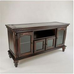 a large wooden entertainment center with glass doors and drawers on one side, in an antique style