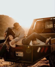 two people sitting in the back of a pick up truck