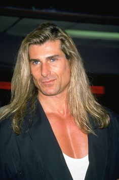 a man with long hair wearing a black jacket