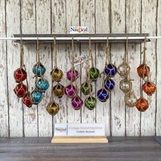 there are many small ornaments hanging on the wall with strings attached to each ornament