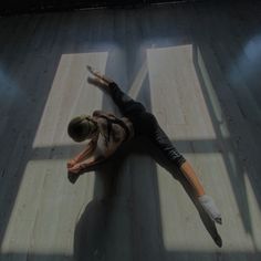 a woman is laying on the floor with her arms outstretched