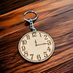 a clock keychain sitting on top of a wooden table