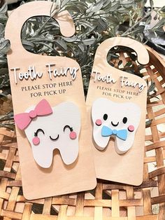 two tooth shaped wooden tags sitting on top of a basket