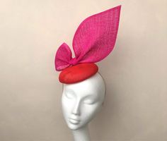 A stunning sculptural sinamay oversized bow detail headpiece, fixed to a round red button base with bright pink sinamay trim. 10% Discount if ordered on my website - rubybose.com  Perfect for any wedding or Royal Ascot (meets Royal Enclosure size regulations) or that finishing touch for your special occasion.  The disc is approx 16 cm in diameter and stands about 25cm high Secured with elastic or a satin covered hairband in a choice of colours to blend your hair colour. I recommend elastic with this shape.   Each piece is handmade by me for you, using the highest quality materials which takes about 5 days, if you have a specific date you need the headpiece please get in touch and I will ensure you receive in good time. If you would like the piece to be made to match your outfit, or adapted Bow Fascinator, Red Fascinator, Pink Fascinator, Bow Wedding, Wedding Fascinators, Wedding Bows, Royal Ascot, Pink Hat, Red Button