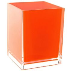 an orange square vase sitting on top of a white table