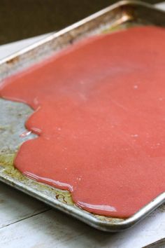 a metal pan filled with red sauce on top of a table