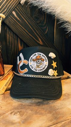 Trucker style hat with patch details and hat chain. Mesh Back | Foam Front | SnapBack Closure Adult Hat One Size Fits Most Trucker Hat Aesthetic, Hat With Patch, Hat Chain, Nfr Style, Authentic Turquoise Jewelry, Country Hats, Hat Aesthetic, Custom Trucker Hats, Top Graphic Tees