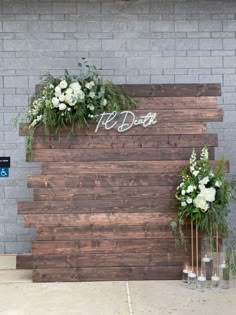 two vases filled with flowers next to a wooden sign