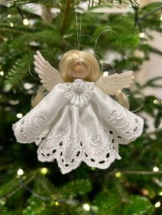 an angel ornament hanging from a christmas tree