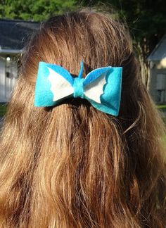 a woman with long hair wearing a blue and white bow tie in front of her head