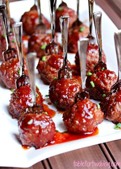 small meatballs with sauce and toothpicks on a white plate, ready to be eaten