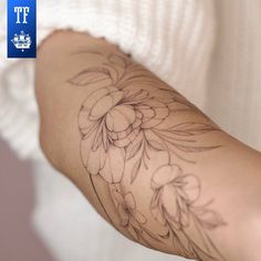 a woman's arm with a flower tattoo on the left side of her arm