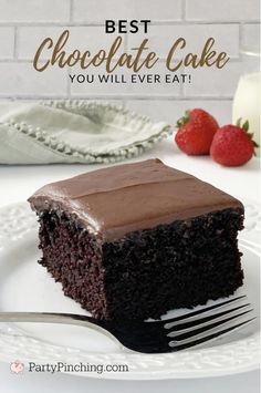 a piece of chocolate cake on a plate with a fork and strawberries in the background