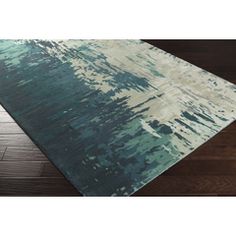 a blue and green area rug on top of a wooden floor with dark wood floors