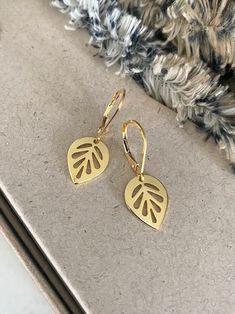 "These 24k gold plated leaf dangle earrings exude elegance with their delicate design, making them perfect for everyday wear. The earrings are finished with gold filled lever backs for a secure wear.  Their subtle shimmer adds a touch of sophistication to any outfit, effortlessly elevating your style. Crafted with attention to detail, they offer a timeless appeal that seamlessly transitions from day to night, ensuring you feel refined and chic at all times.  Also available in rhodium plated finished with sterling silver lever backs. The earrings measure just over 1\" from end to end.  The leaf charms are approx 14x11mm. You may also like to check out more of my earrings here: http://etsy.me/2e2BGZl Free first class USPS domestic USA shipping" Gold Leaf-shaped Single Earring, Gold Single Leaf-shaped Earring, Elegant Leaf-shaped Everyday Jewelry, Elegant Everyday Leaf-shaped Jewelry, Gold Leaf-shaped Hoop Earrings For Gift, Gold Leaf Earrings For Gift, Gold Leaf-shaped Earrings For Gift, Gold Delicate Hypoallergenic Teardrop Earrings, Gold Leaf-shaped Earrings