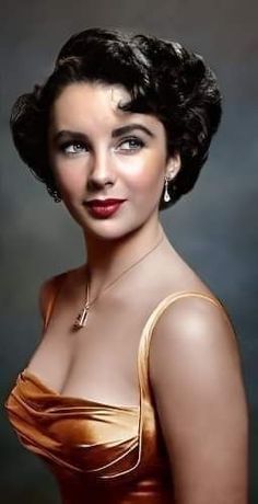 an old photo of a woman wearing a gold dress and diamond necklace, posing for the camera