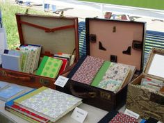 several suitcases are lined up on a table with notepads and notebooks