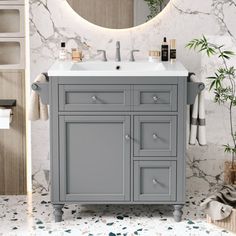 a bathroom vanity with marble counter top and mirror above it, next to a bamboo plant